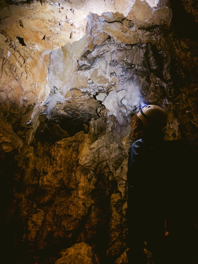 Fanny en spéléo devant une salle de la grotte