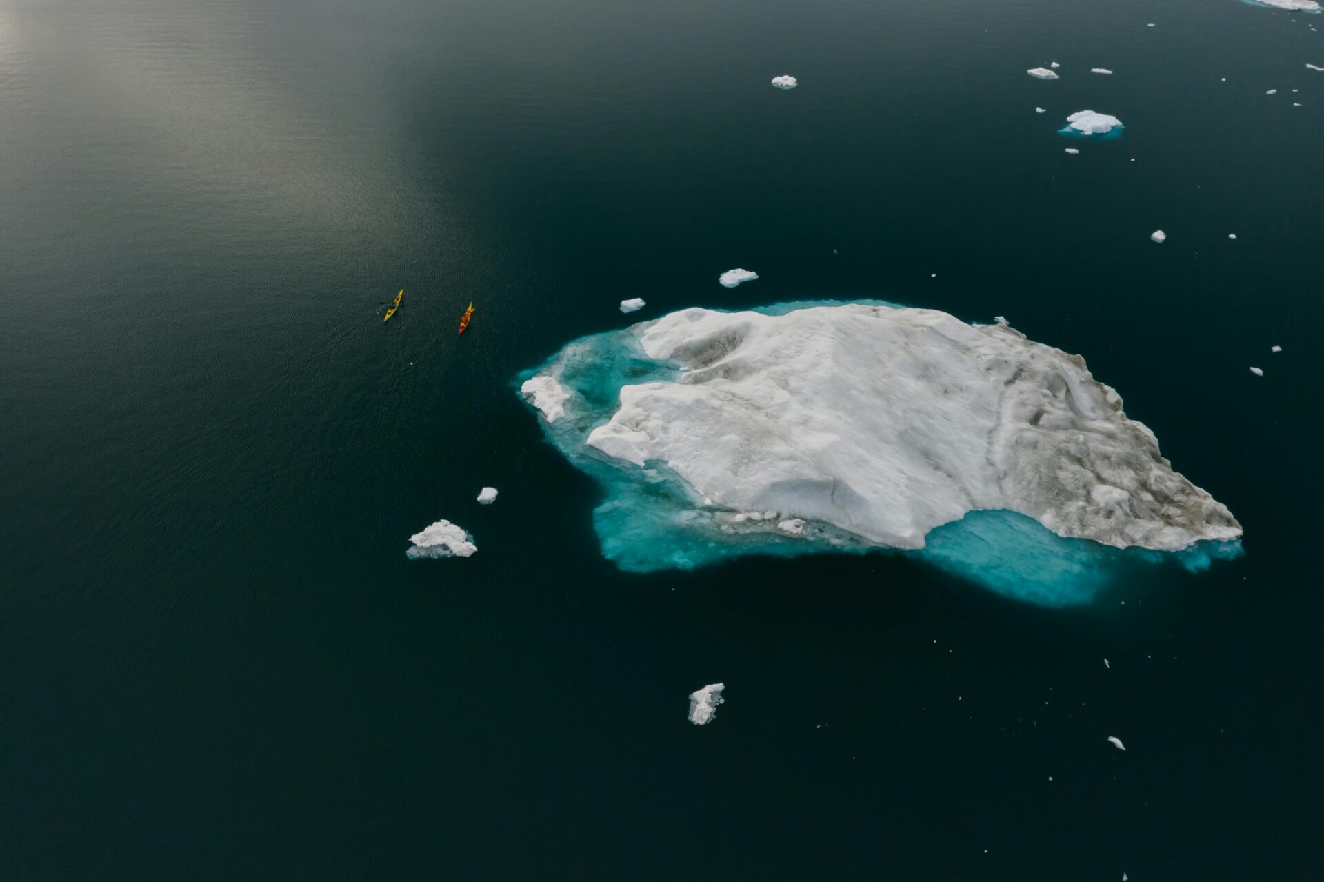 Vivre le changement climatique, des canoës près d'un bloc de glace