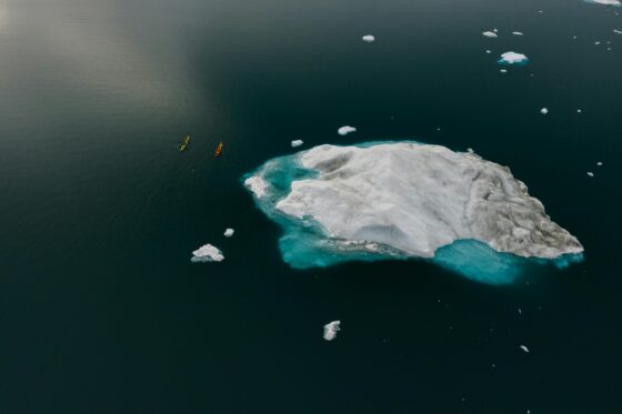 Vivre le changement climatique, des canoës près d'un bloc de glace
