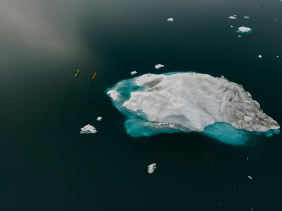 Vivre le changement climatique, des canoës près d'un bloc de glace