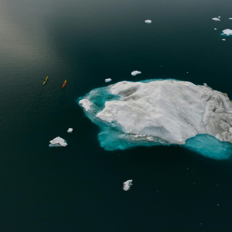 Vivre le changement climatique, des canoës près d'un bloc de glace