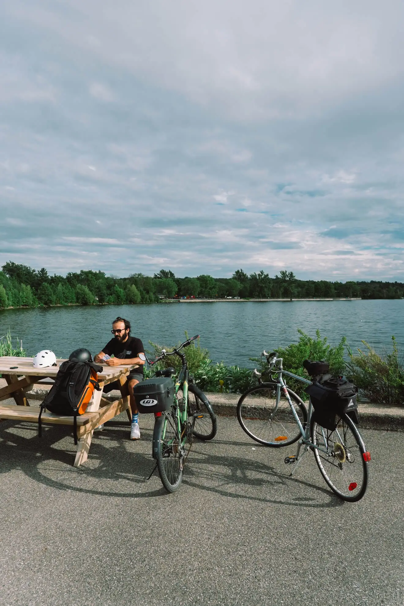 homme avec des vélos près d'un lac