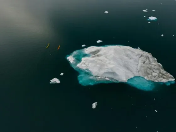 Vivre le changement climatique, des canoës près d'un bloc de glace